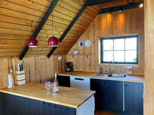 a kitchen with wooden walls and a counter with glasses on it at 20039-Ulfborg-Sortebaervej-8 in Ulfborg