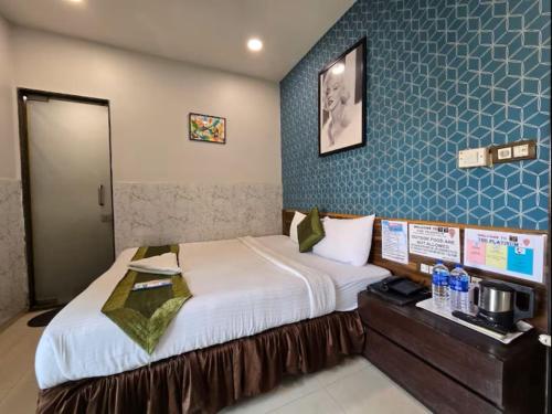 a bedroom with a bed and a blue wall at The Platinum in Kolkata