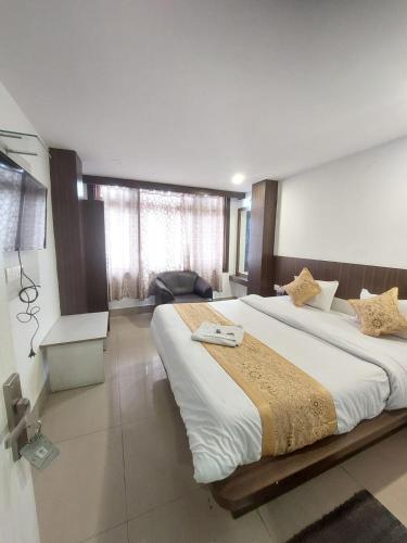 a large bedroom with two beds and a chair at Hotel white lion-Near Bhajra Taxi Stand in Gangtok