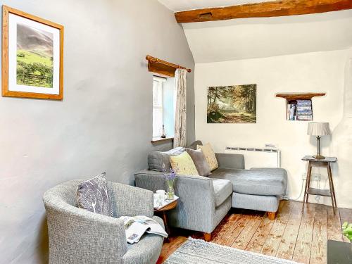 a living room with two chairs and a couch at Rebecca Puddle Duck Cottage in Bassenthwaite