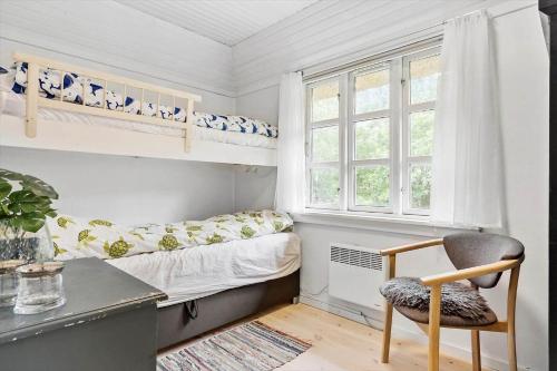 a small bedroom with a bunk bed and a chair at 10173-Ulfborg-Gaffelbjergvej-24 in Ulfborg