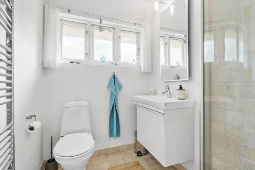 a white bathroom with a toilet and a sink at 10173-Ulfborg-Gaffelbjergvej-24 in Ulfborg