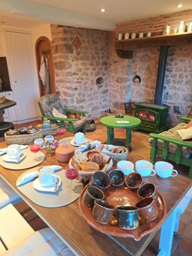 a table with a bunch of food on it at Maison la Bambine chambre nature in Ozolles