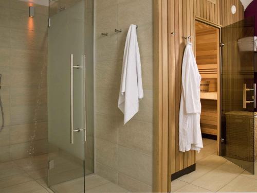 a bathroom with a shower with a glass door at Mercure Grand Hotel Biedermeier Wien in Vienna