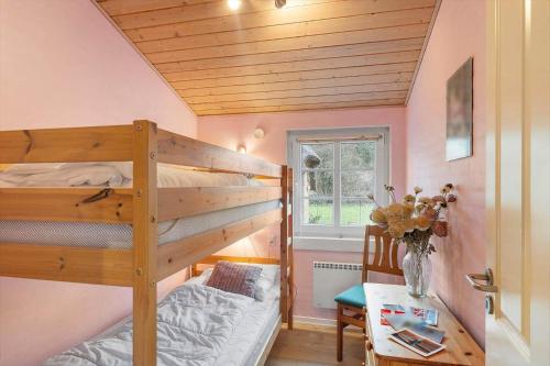 a bedroom with two bunk beds and a table at 30848-Ulfborg-Valmuevej-286 in Ulfborg