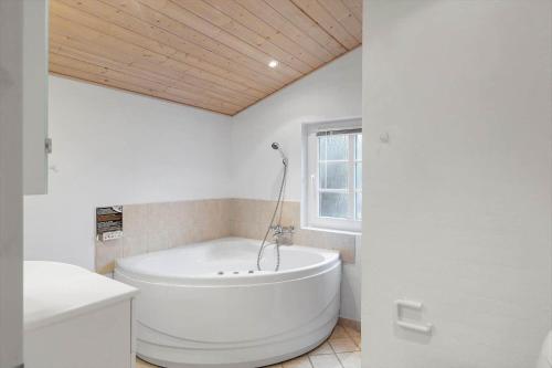 a large white tub in a bathroom with a window at 30848-Ulfborg-Valmuevej-286 in Ulfborg