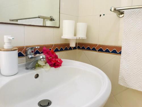 a white bathroom sink with a flower on it at Secure villa in a quiet garden with pool in Albion