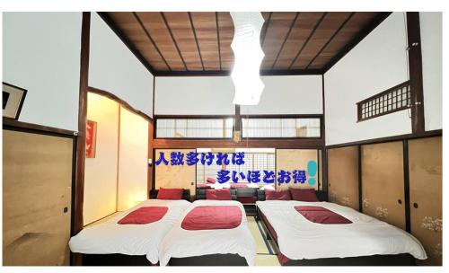 a room with three beds in the middle of it at 古民家白馬 in Nagano