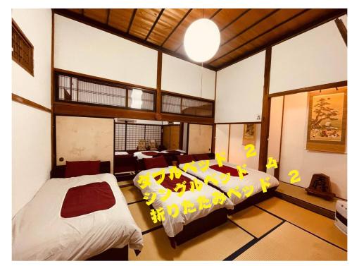 a bedroom with two beds and a living room at 古民家白馬 in Nagano
