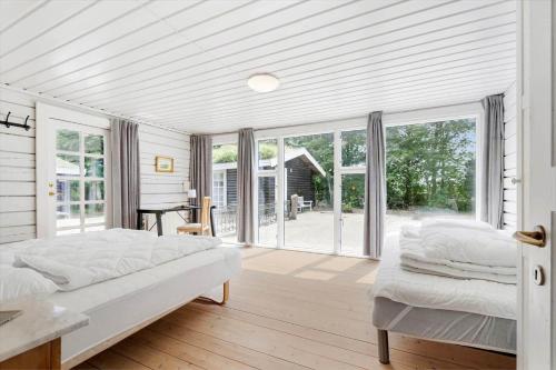 a white bedroom with a bed and sliding glass doors at 80182-Vemb-Ogelstrupvej-4 in Vemb