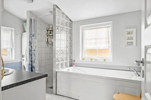 a white bathroom with a tub and a shower at 10808-Ulfborg-Vester-Mosevej-84 in Ulfborg