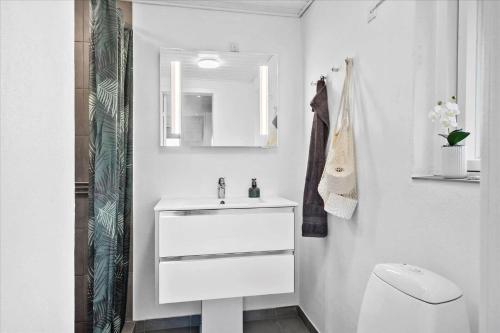 a bathroom with a white sink and a toilet at 20041-Ulfborg-Knakvej-10 in Ulfborg