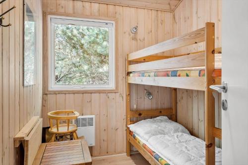 a bedroom with two bunk beds and a chair at 30872-Ulfborg-Bellisvej-514 in Ulfborg
