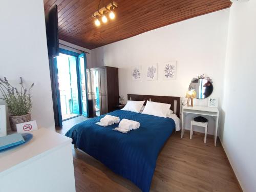 a bedroom with a blue bed with two towels on it at Rooms of Nectar in Poros