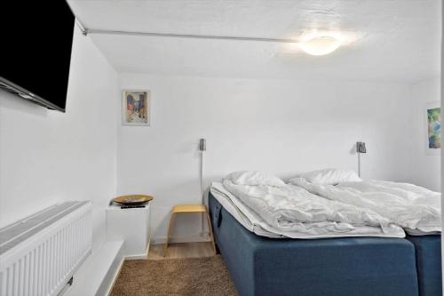 a bedroom with a blue bed with a tv on it at 70181-Ulfborg-Enghavevej-2 in Ulfborg