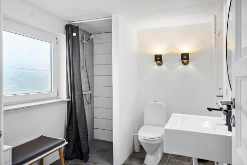 a bathroom with a toilet and a sink and a window at 70181-Ulfborg-Enghavevej-2 in Ulfborg