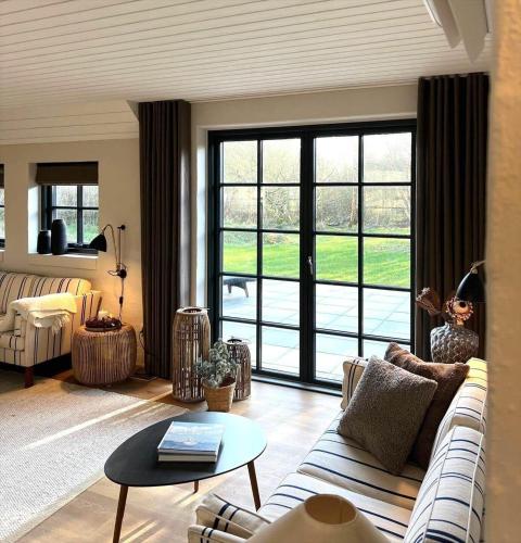 a living room with a couch and a large window at 10735-Ulfborg-Graevlingevej-11 in Ulfborg