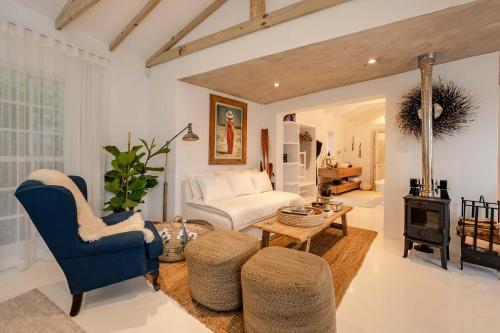 a living room with a couch and a stove at Long Story Guest House in Plettenberg Bay