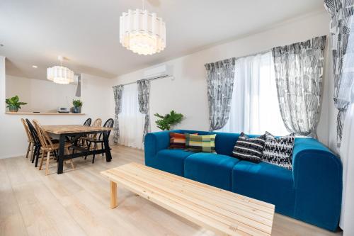 a living room with a blue couch and a table at Villa Gotemba Holidays in Gotemba