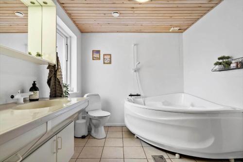 a white bathroom with a tub and a toilet at 30789-Ulfborg-Akelejevej-276 in Ulfborg