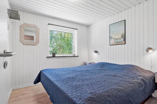 a bedroom with a blue bed and a window at 30789-Ulfborg-Akelejevej-276 in Ulfborg