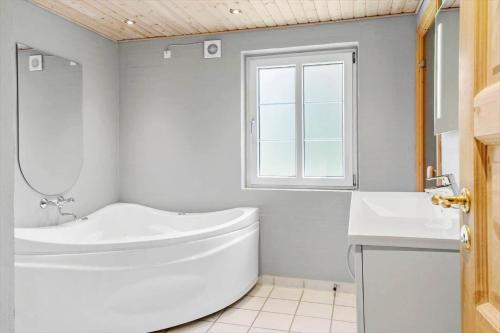 a white bathroom with a tub and a sink at 10718-Ulfborg-Baekbyvej-117 in Ulfborg