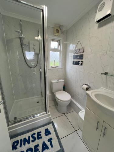 a bathroom with a shower and a toilet and a sink at 'Sunnyside' Chalet, walk to the beach & close to Norfolk broads - pet friendly! in Great Yarmouth