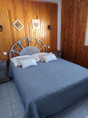 a bedroom with a blue bed with a wooden wall at La Céret'nitude in Céret