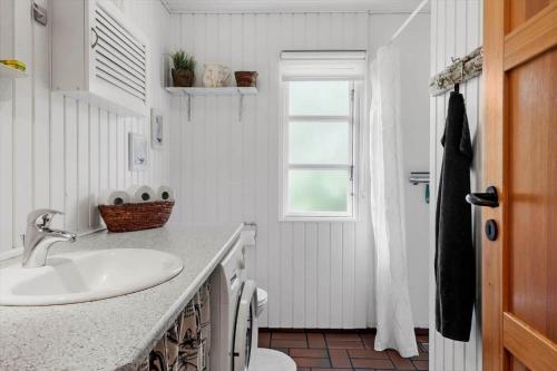 a white bathroom with a sink and a window at 80262-Vemb-Hyttevej-103 in Vemb
