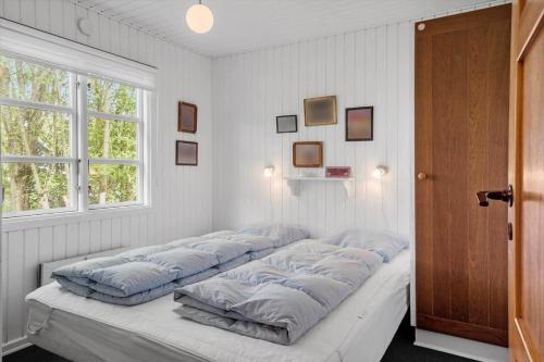 a bed with four pillows on it in a room at 80262-Vemb-Hyttevej-103 in Vemb
