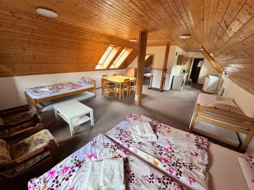 a room with two beds and a room with tables at Chata Boubín in Kubova Huť