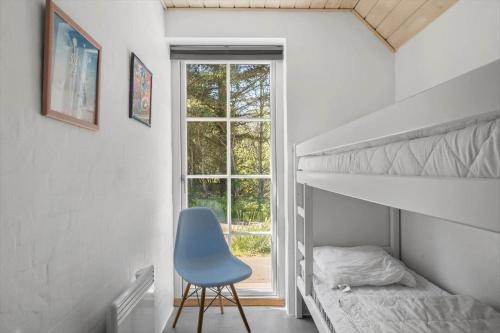 a bedroom with a bunk bed and a blue chair at 10611-Ulfborg-Gaffelbjergvej-6 in Ulfborg