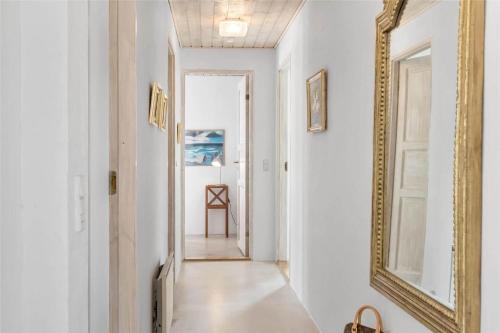 a hallway with a mirror on the wall and a hallway with a table at 10611-Ulfborg-Gaffelbjergvej-6 in Ulfborg