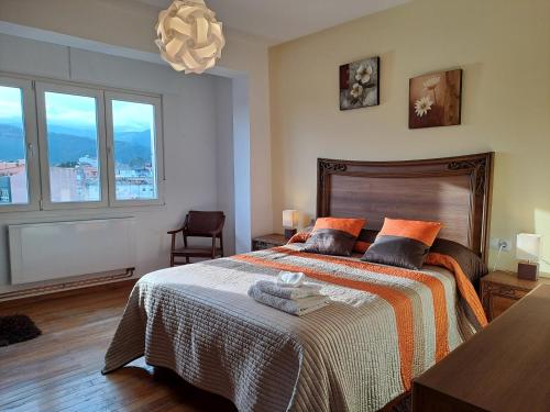 a bedroom with a large bed with a large window at Torre Plaza 5 in Boiro