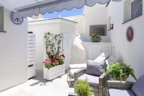 a patio with flowers and plants on a white building at Casa Borgo Sant'Angelo in Sant'Angelo D'Ischia