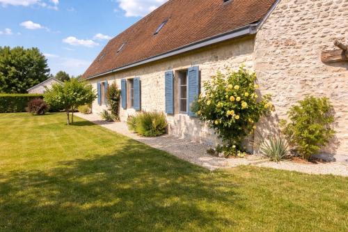 an old stone building with a grass yard at La longère du golf in Verneuil-sur-Indre