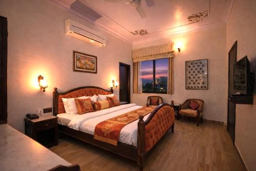 a bedroom with a large bed and a window at Harnawa Haveli - A Boutique Heritage Stay in Jaipur in Jaipur