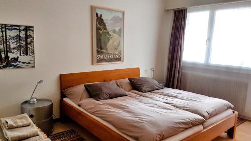 a bed in a room with a large window at Haus Silberblick Anrig in Grächen