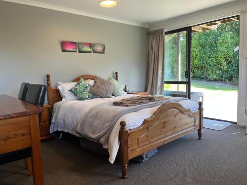 a bedroom with a bed and a desk and a window at Hampden Heaven in Hampden