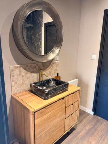 a bathroom with a sink with a mirror on the wall at Refuge des Dunes in Marck