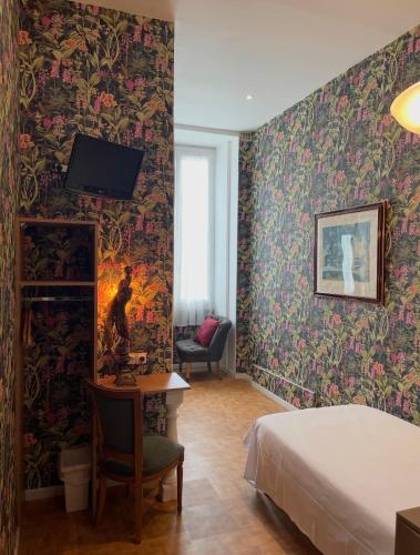 a bedroom with a bed and a desk with a tv at Interlaken in Nice
