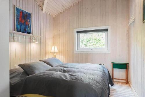 a bedroom with a bed and a window at 30816-Ulfborg-Oster-Skovvej-67 in Ulfborg
