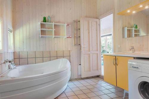 a bathroom with a tub and a washing machine at 30816-Ulfborg-Oster-Skovvej-67 in Ulfborg