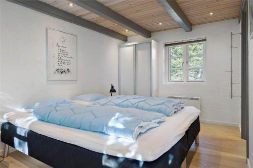 a large bed with a blue comforter in a room at 20132-Ulfborg-Tyttebaervej-19 in Ulfborg
