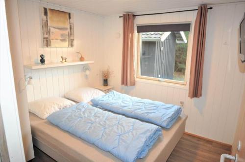 a bed with blue sheets in a room with a window at 30171-Ulfborg-Snerlevej-492 in Ulfborg