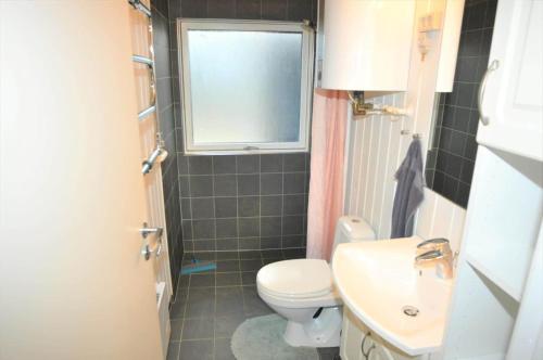 a bathroom with a toilet and a sink and a window at 30171-Ulfborg-Snerlevej-492 in Ulfborg