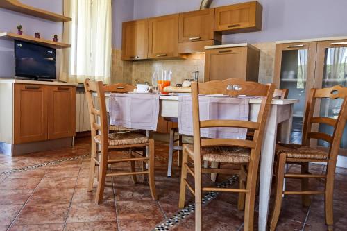 a kitchen with a table with chairs and a television at Villetta Dino in Vada