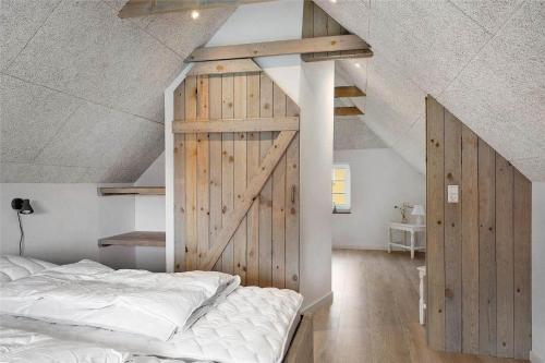 a bedroom with a sliding barn door and a bed at 70240-Ulfborg-Vesterhavsgade-12 in Ulfborg