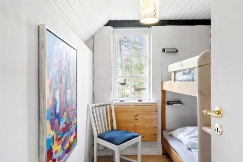a bedroom with a bed and a chair and a window at 30327-Ulfborg-Grastensborgvej-38 in Ulfborg