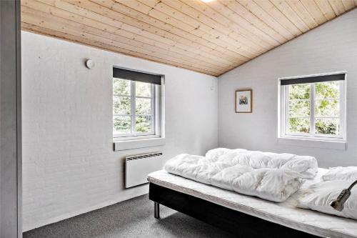 a bed in a room with two windows at 10878-Ulfborg-Graemvej-31 in Ulfborg